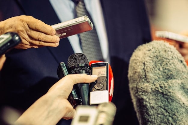 A close-up of a mobile journalist connecting an external microphone to their smartphone. The microphone is a professional lavalier mic, and the journalist is focused on ensuring a secure and high-quality audio connection.