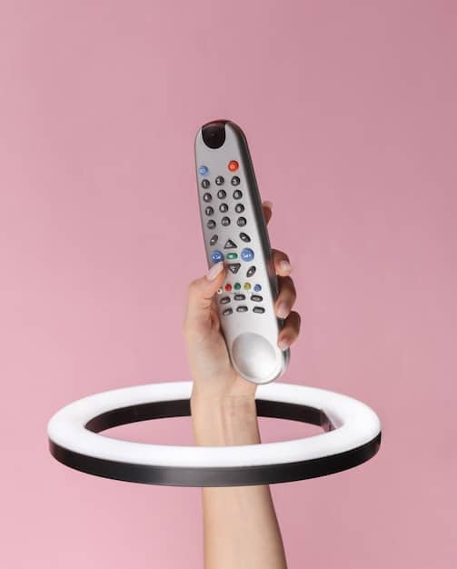 A hand holding a television remote control with news channels displayed, where a corporate logo is subtly shown on the corner of the screen, representing bias in media.