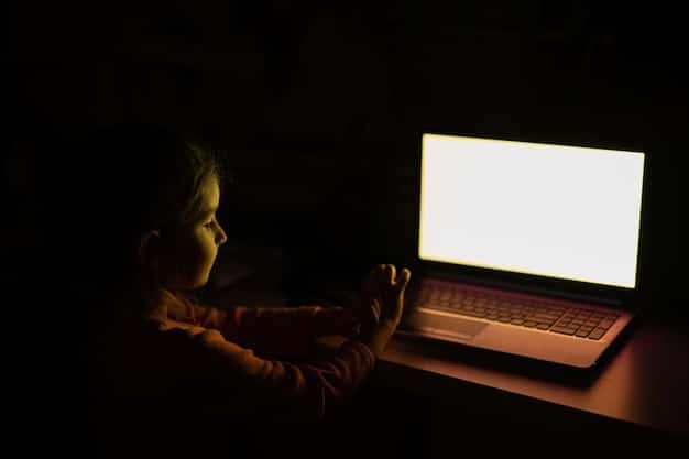 A person sitting alone in a dark room, illuminated by the glow of a laptop screen, looking visibly distressed, representing the potential isolation and mental health issues caused by excessive social media use.